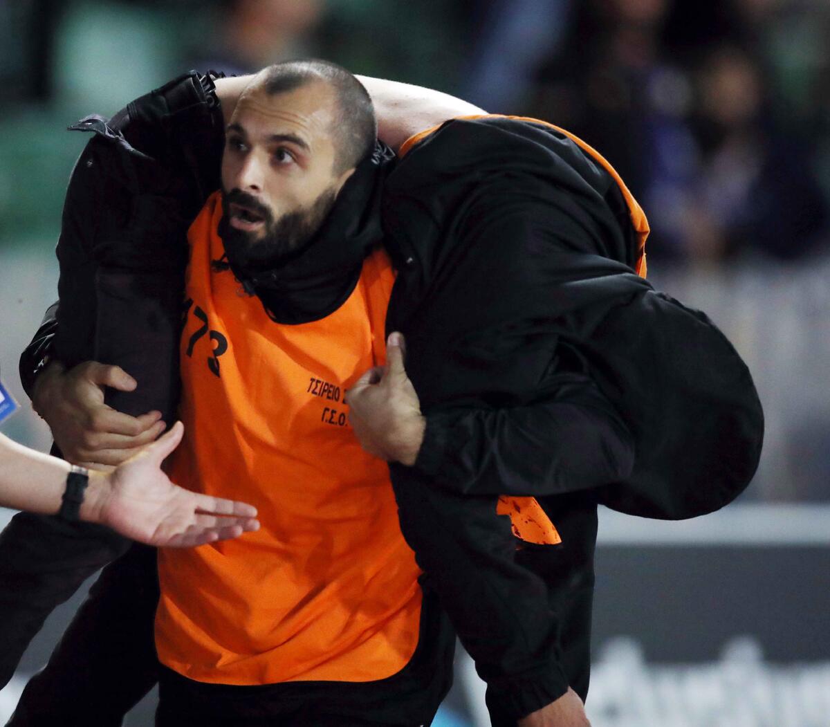 Συγκλονιστική φωτογραφία: Ο steward πήρε στην πλάτη του τον οπαδό του ΑΠΟΕΛ! thumb